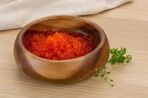 Red caviar in a bowl on wooden background photo