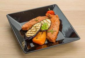 Pork steak on the plate and wooden background photo