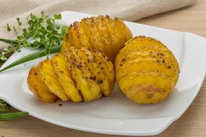 Baked potato on the plate and wooden background photo