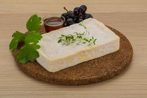 Brie cheese on wooden board and wooden background photo