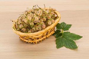 White currant in a basket on wooden background photo