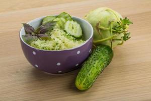 Kohlrabi salad in a bowl on wooden background photo