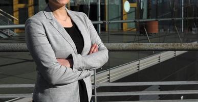 Anonymous female professional in a black shirt and grey suit jacket in an urban environment photo