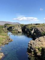 Agua clara y formaciones rocosas en Thingvellir, Islandia, en un día soleado foto