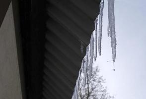 Icicles hanging from a roof of a barn photo