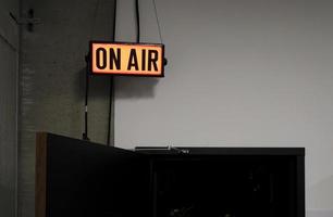 Glowing On Air sign over a door leading to TV studio photo