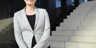 Anonymous female professional in a black shirt and grey suit jacket in an urban environment photo