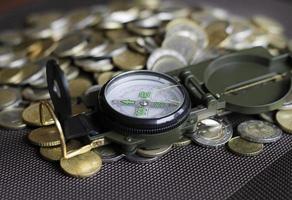 Finding the right investment strategy - compass on a pile of money photo