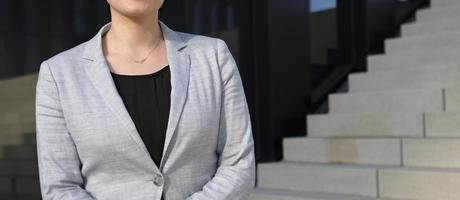 Anonymous female professional in a black shirt and grey suit jacket in an urban environment photo