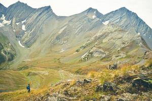 Side view happy tourist female hiker smile look to camera on viewpoint uphill in green hiking trail in caucasus mountains .Recreational activities and healthy lifestyle photo