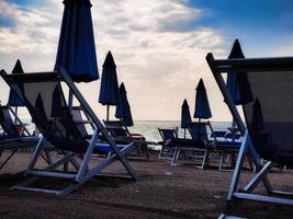 sombrillas en la playa a fines del verano en la riviera de liguria occidental foto