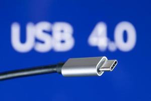 USB4 plug cable on blue background with USB 4.0 text. New computer USB protocol photo