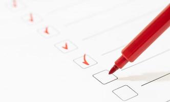 Red marker with markers on the checklist sheet. Checklist completed task concept photo