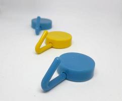 Isolated white photo of three round coat hangers with blue and yellow colors.