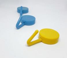 Isolated white photo of three round coat hangers with blue and yellow colors.