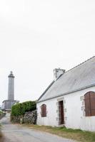 Batz island. Traditional architecture and lighthouse in the distance photo