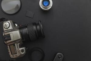 Photographer work place work space with dslr camera system, camera cleaning kit, lens and camera accessory on dark black background. Hobby travel photography concept. Flat lay top view, copy space photo