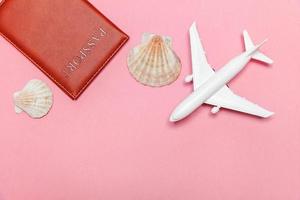 Minimal simple flat lay travel adventure trip concept with plane and passport on pink pastel trendy modern background photo