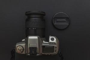 Photographer workplace with dslr camera system on dark black table background. Hobby travel photography concept. Flat lay top view copy space. photo