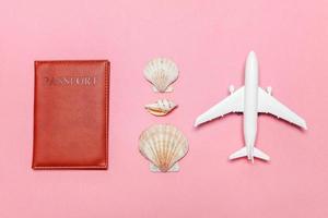 Minimal simple flat lay travel adventure trip concept with plane and passport on pink pastel trendy modern background photo