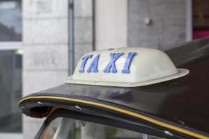 Taxi sign on the roof of a tuk tuk photo