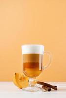 bright pumpkin spice latte in a glass mug with cinnamon photo