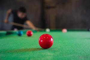 cerca de la bola de billar blanca y roja o de la piscina en la mesa de billar. juego de billar de competencia de jugador de billar, apuesta. deporte de billar interior. foto