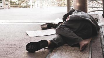 Homeless man sleeping on outdoor floor. photo