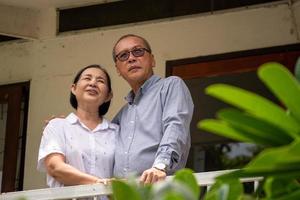 Happy asian couples standing at the balcony and talking together. photo