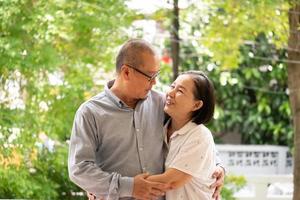 felices parejas asiáticas de pie y abrazándose juntas en el parque. foto