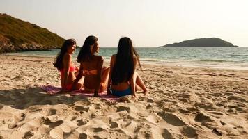 tres mujeres sexy sentadas juntas en la playa. foto