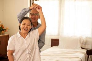 felices parejas asiáticas bailando juntas en el dormitorio. foto