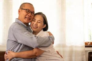 Happy asian couples sitting and hugging together in the house. photo