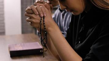 A young Asian Christian couple praying to Jesus Christ in a church. photo