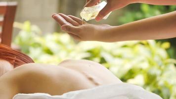 Massage therapist pouring essential oil for massage at spa. photo