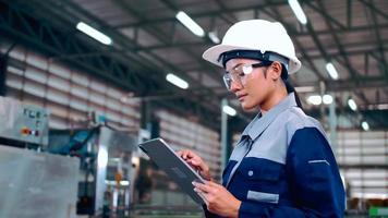 Engineer is using a tablet to check the machine's control system in a factory. photo