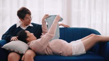 Pregnant Asian lesbian woman and her partner are happy to spend time together at home. photo