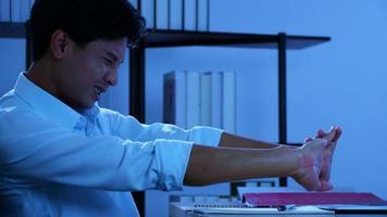 Office man sitting and working pain, He aches the body. And try to stretch the body, Over work at night in office photo