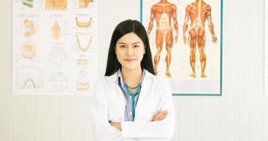 Beautiful doctor smiling and standing at doctor's room. photo