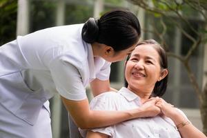 hermosa enfermera cuidando a una paciente en el parque del hospital foto
