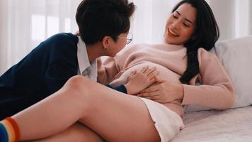 Pregnant Asian lesbian woman and her partner are happy to spend time together at home. photo