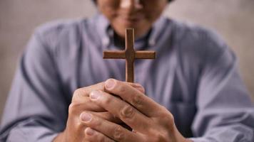 A young Asian Christian man praying to Jesus Christ in a church. photo