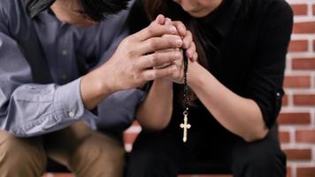 A young Asian Christian couple praying to Jesus Christ in a church. photo
