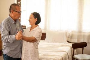 felices parejas asiáticas bailando juntas en el dormitorio. foto