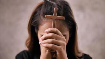 A young Asian Christian woman praying to Jesus Christ in a church. photo