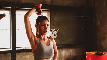mujer atractiva haciendo ejercicio con pesas en el gimnasio. foto