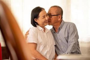 Asian husband kissing on his wife cheek. photo