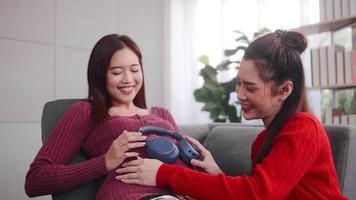 Happy pregnant lesbian couple spending time together at home. photo