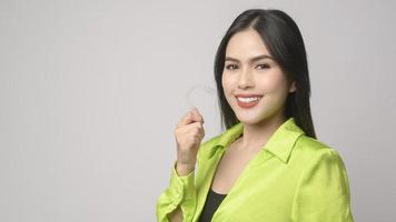 Young smiling woman holding invisalign braces in studio, dental healthcare and Orthodontic concept photo