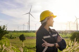 a woman engineer is putting a protective helmet on her head at sunset. photo